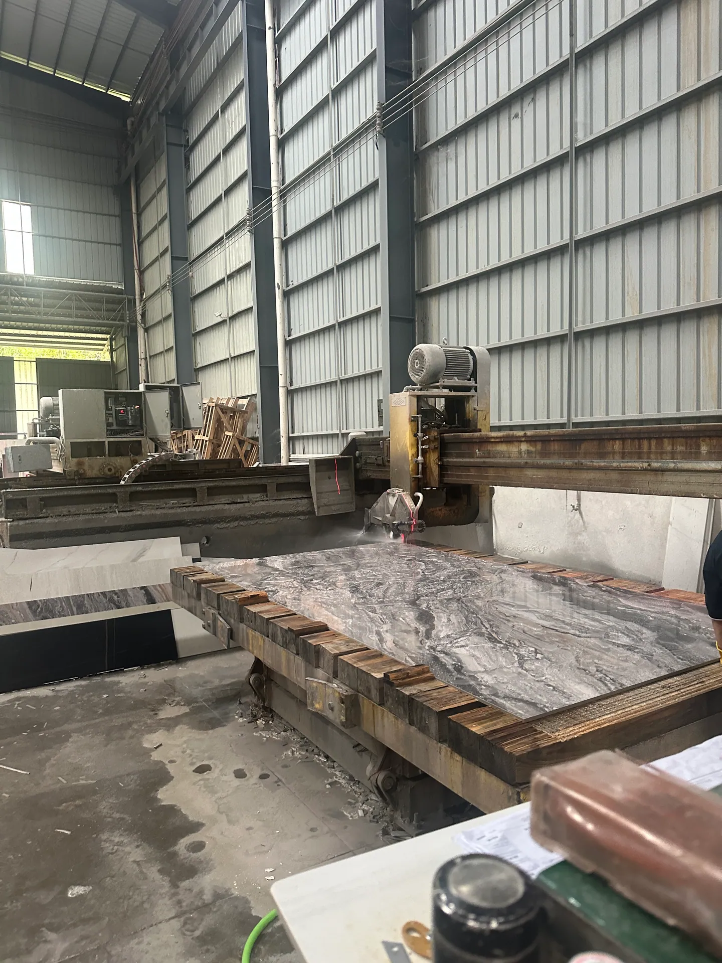 Stone slab cutting equipment inspected for a VELA Home Global building-material sourcing project
